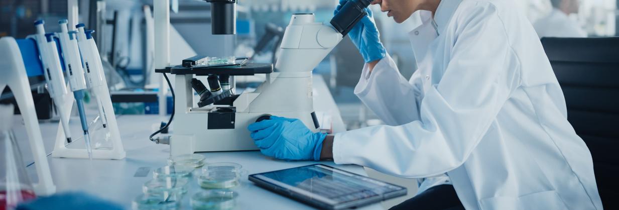 Healthcare worker looking through a microscope