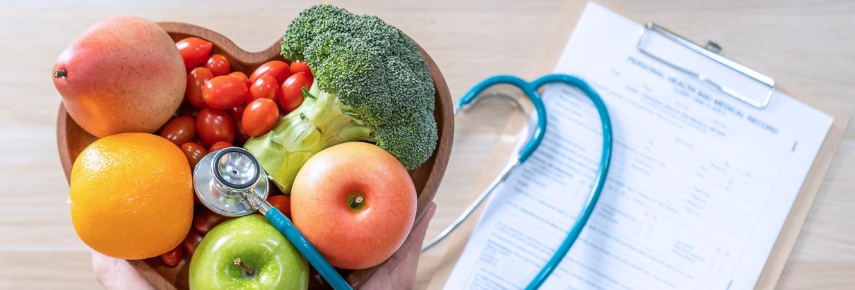 Foods in a bowl, stethoscope, and paperwork