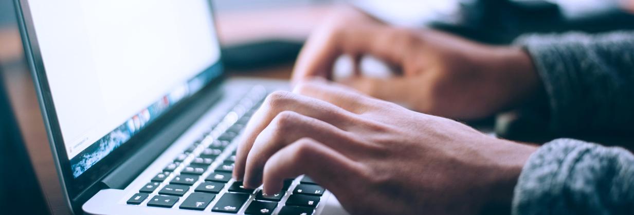 Healthcare worker typing on a laptop keyboard