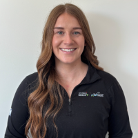 Woman with long reddish/brown hair wearing a black sweater