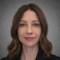 Girl with short brown curly hair wearing a black blazer
