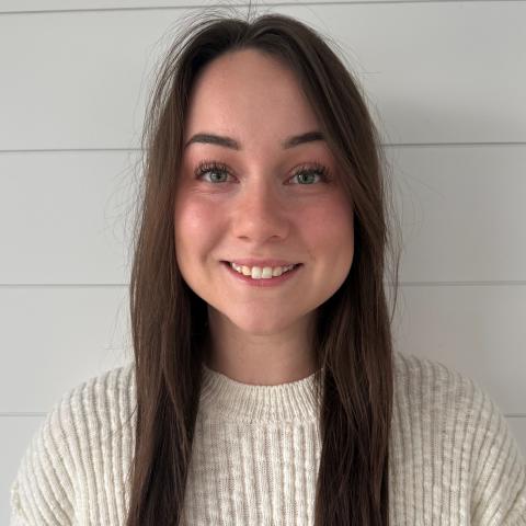 woman with long brown hair wearing a white sweater
