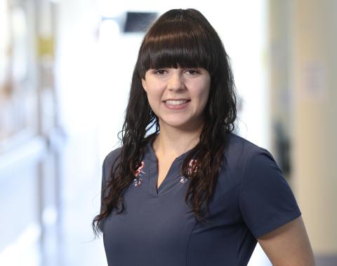 woman with brown hair and blue scrubs