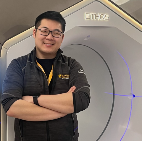 man with black glasses and grey sweater